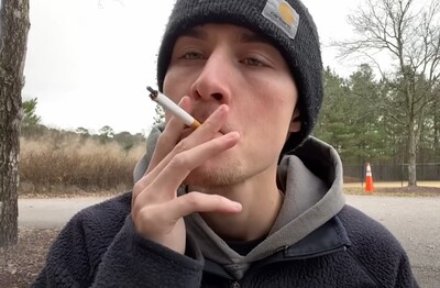 Лечение зависимости от табакокурения в ЦАО Москвы Мужчина с сигаретой делает затяжку